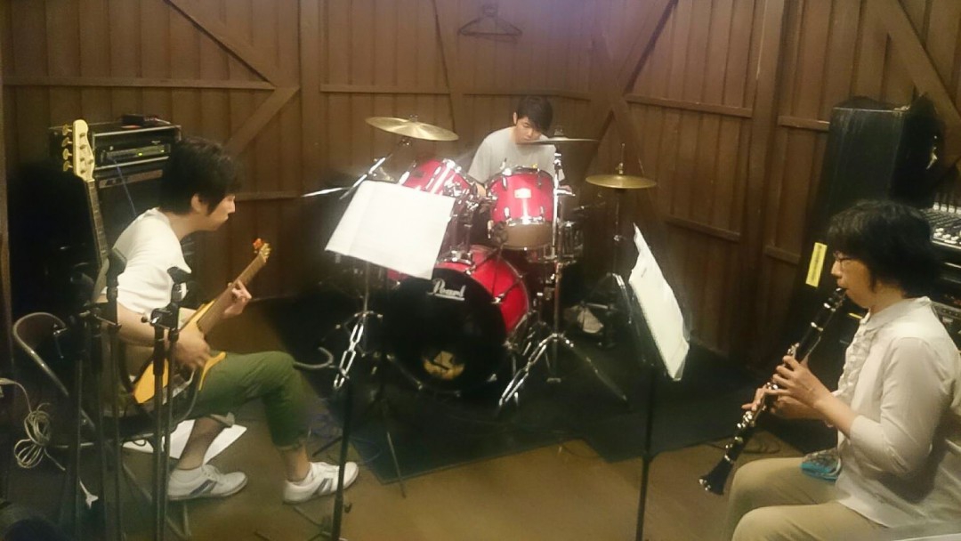 ドラムとギターと一緒にクラリネットを演奏する生徒