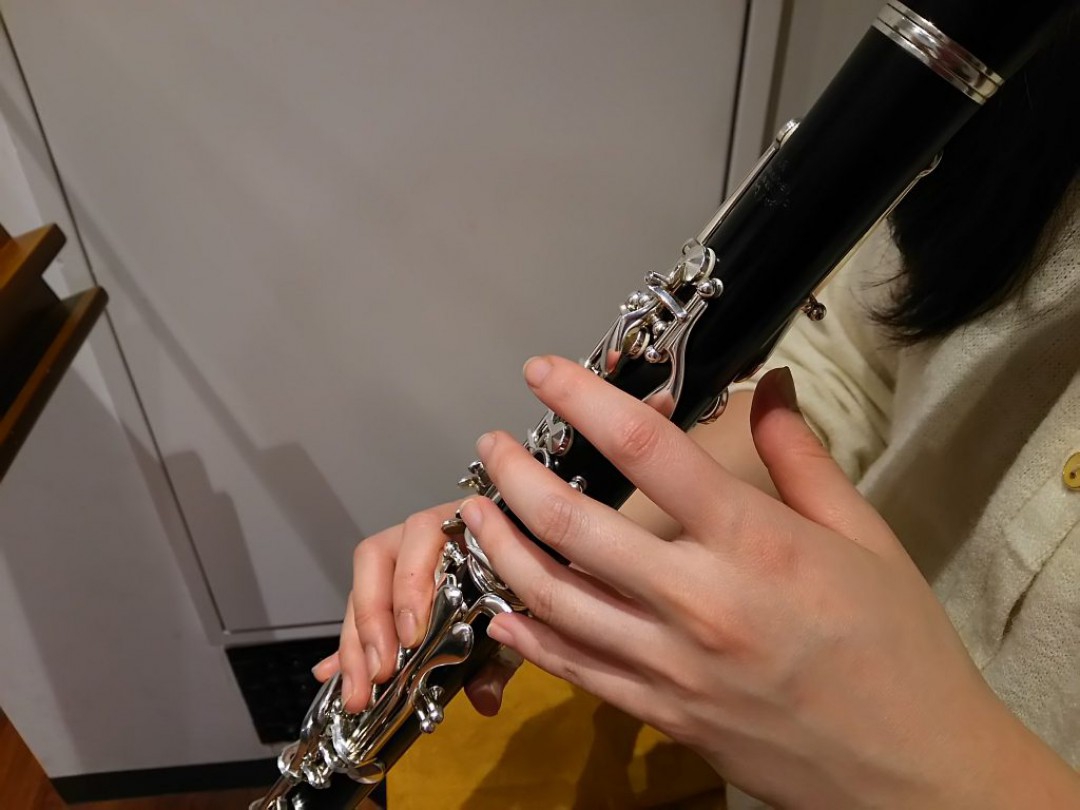 指を確認しながらクラリネットを演奏する生徒