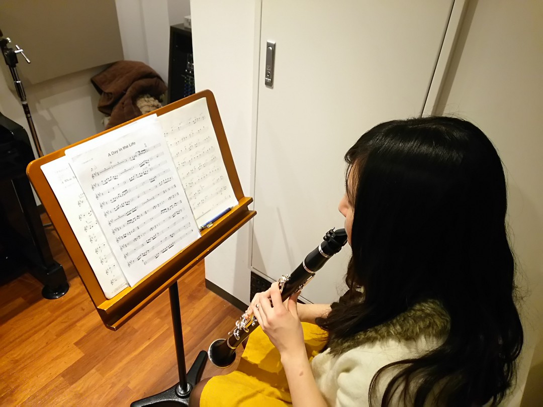 楽譜を見ながらクラリネットを演奏する生徒