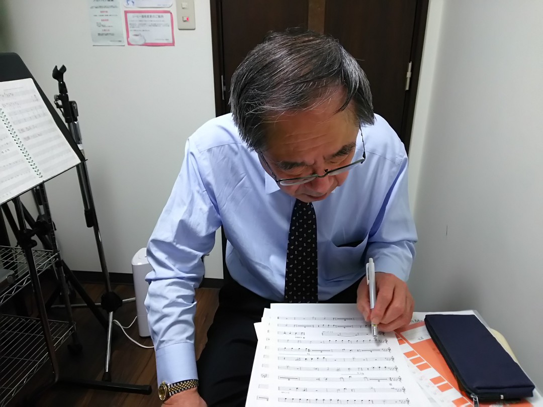 楽譜にメモを書き込み楽曲を確認する生徒