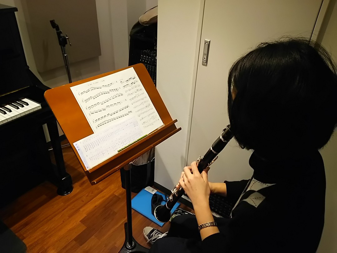 譜面台に置かれた楽譜を見ながらレッスンを受ける生徒