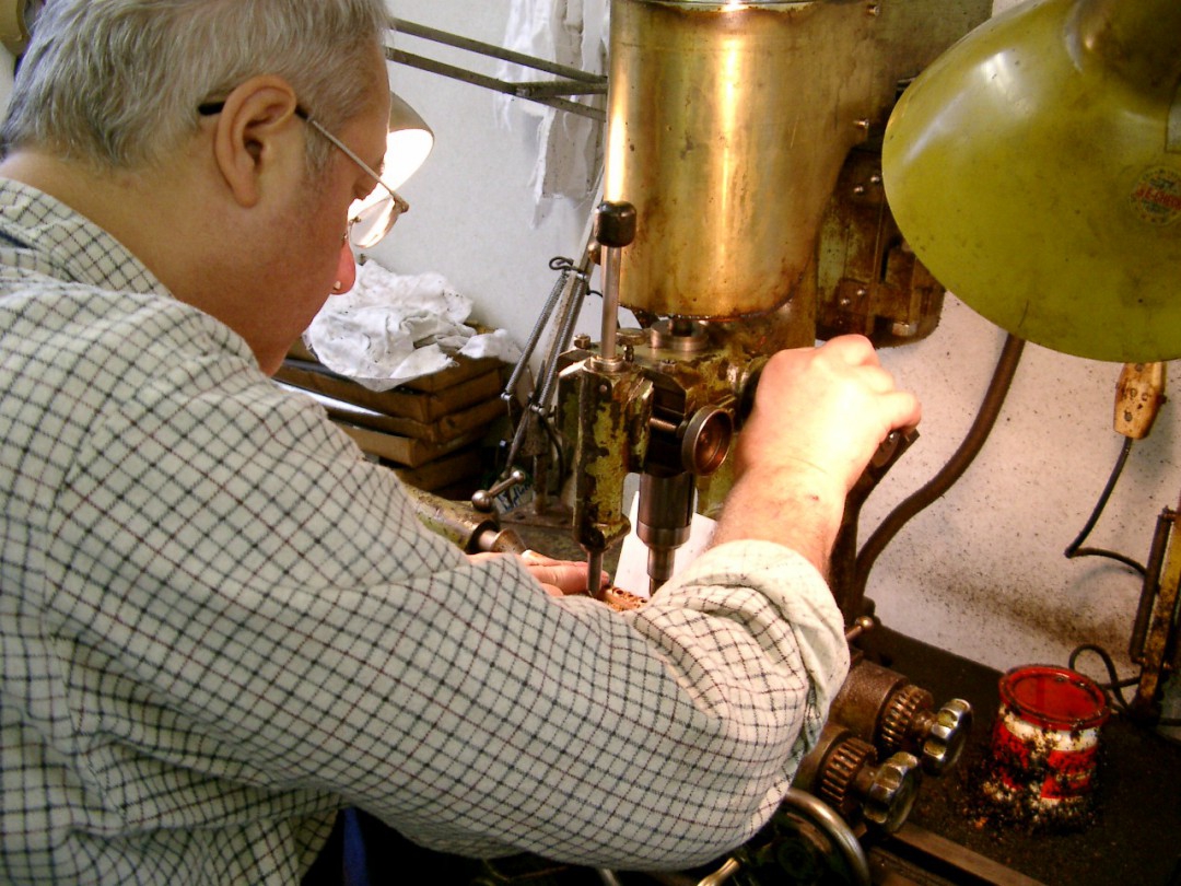 機械でピッコロの管体に指穴を開ける職人さん