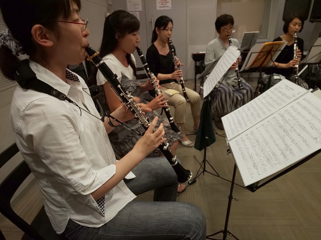楽譜を見ながらクラリネットを演奏する生徒
