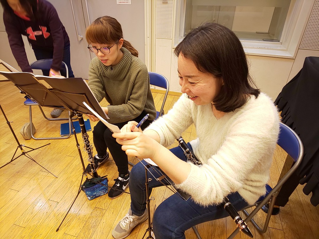 笑顔で楽譜に書き込みをする生徒達