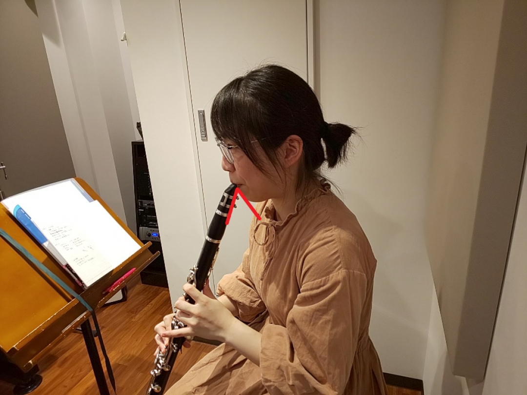 上目遣いになってクラリネットを吹いている生徒