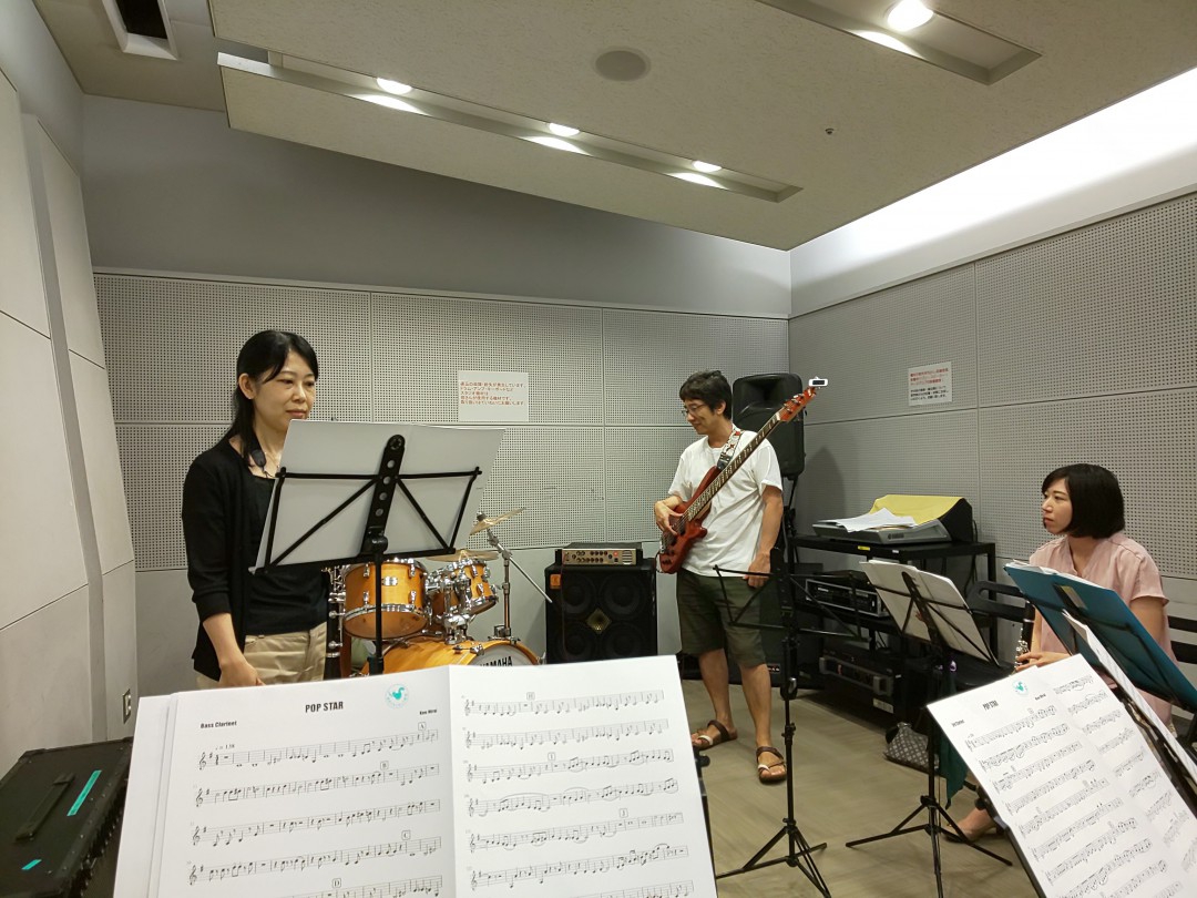 ソリストが立って演奏する準備をしているバンドアンサンブル