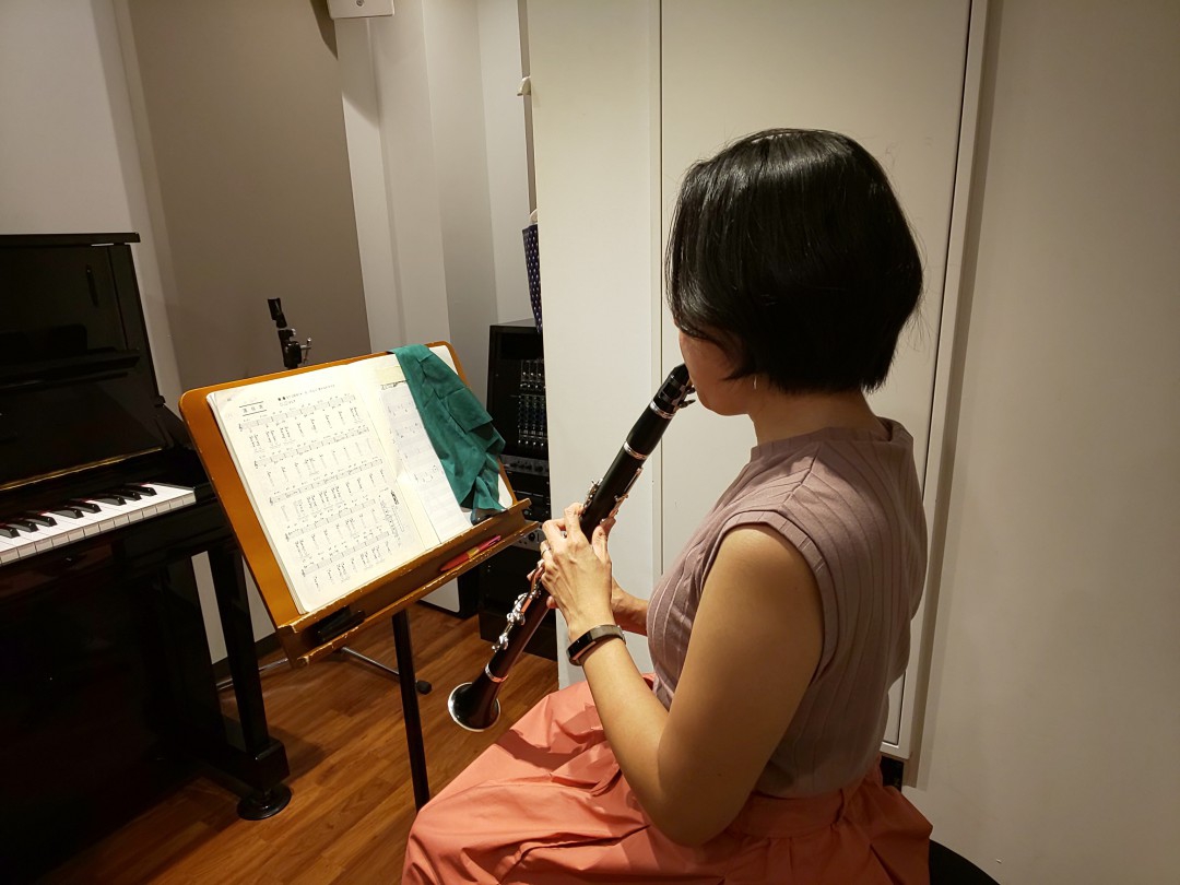 楽譜を見ながら座って演奏する生徒
