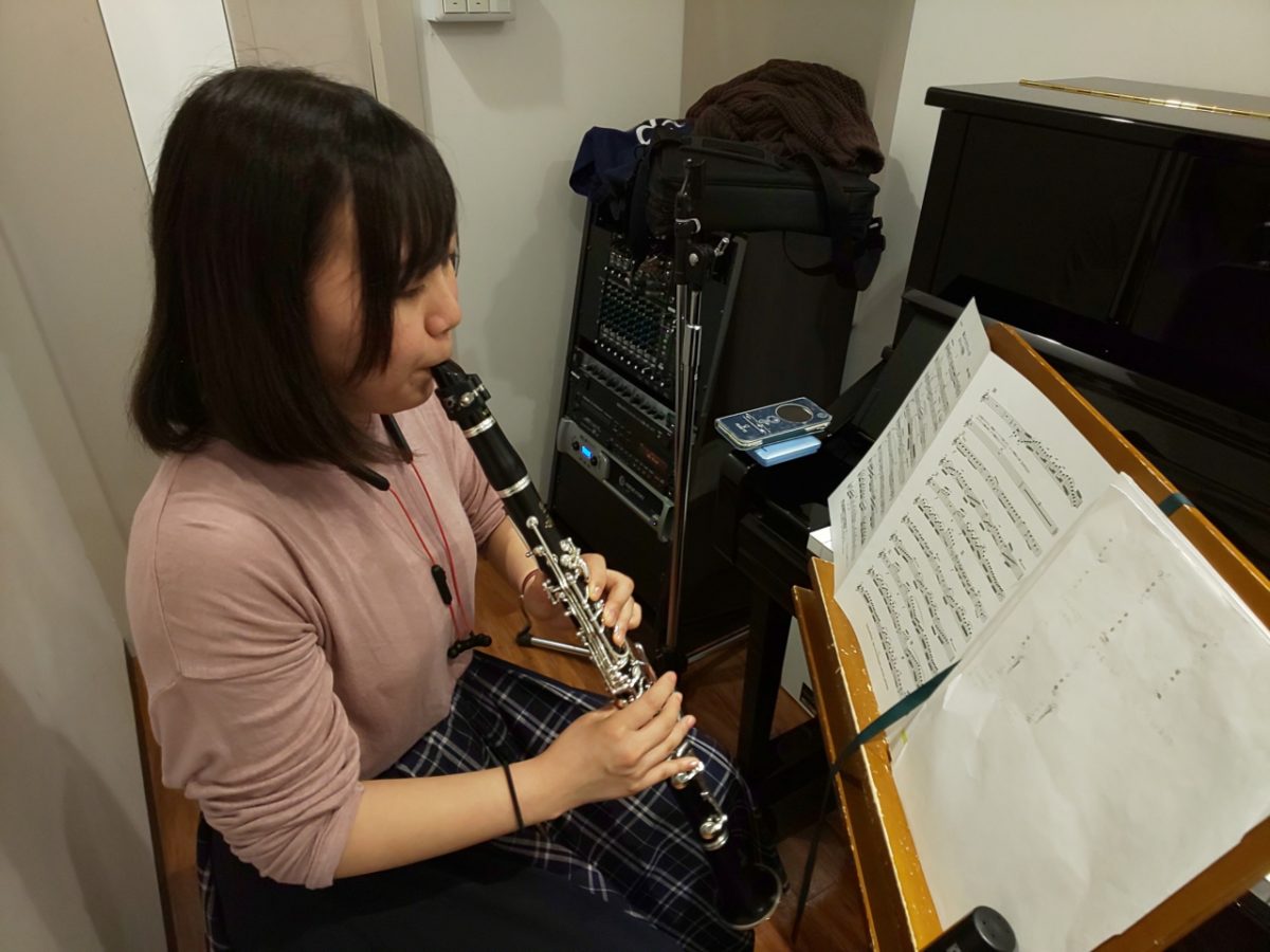 楽譜を見ながら座って演奏する生徒