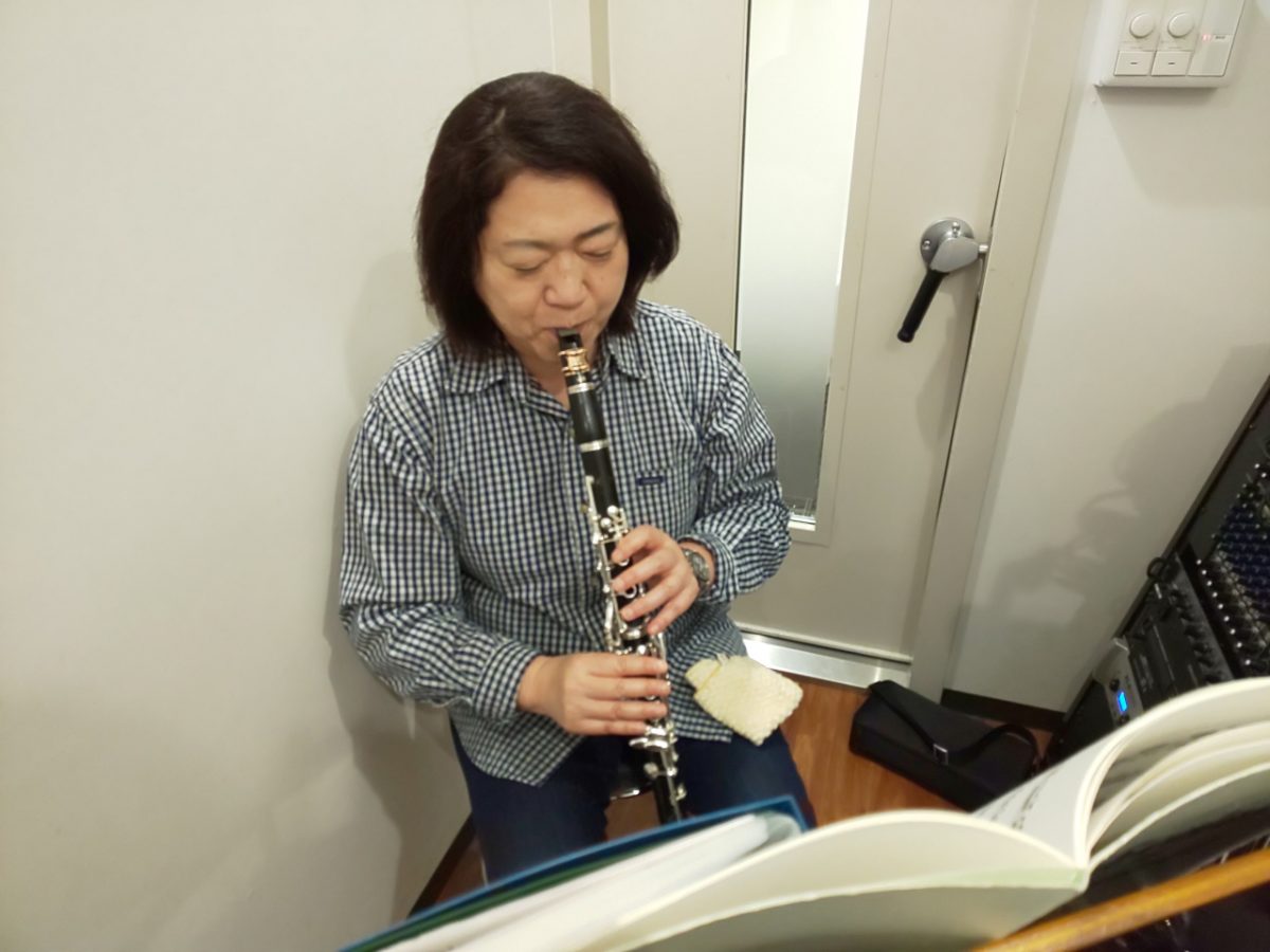 楽譜を見ながら座って演奏する生徒