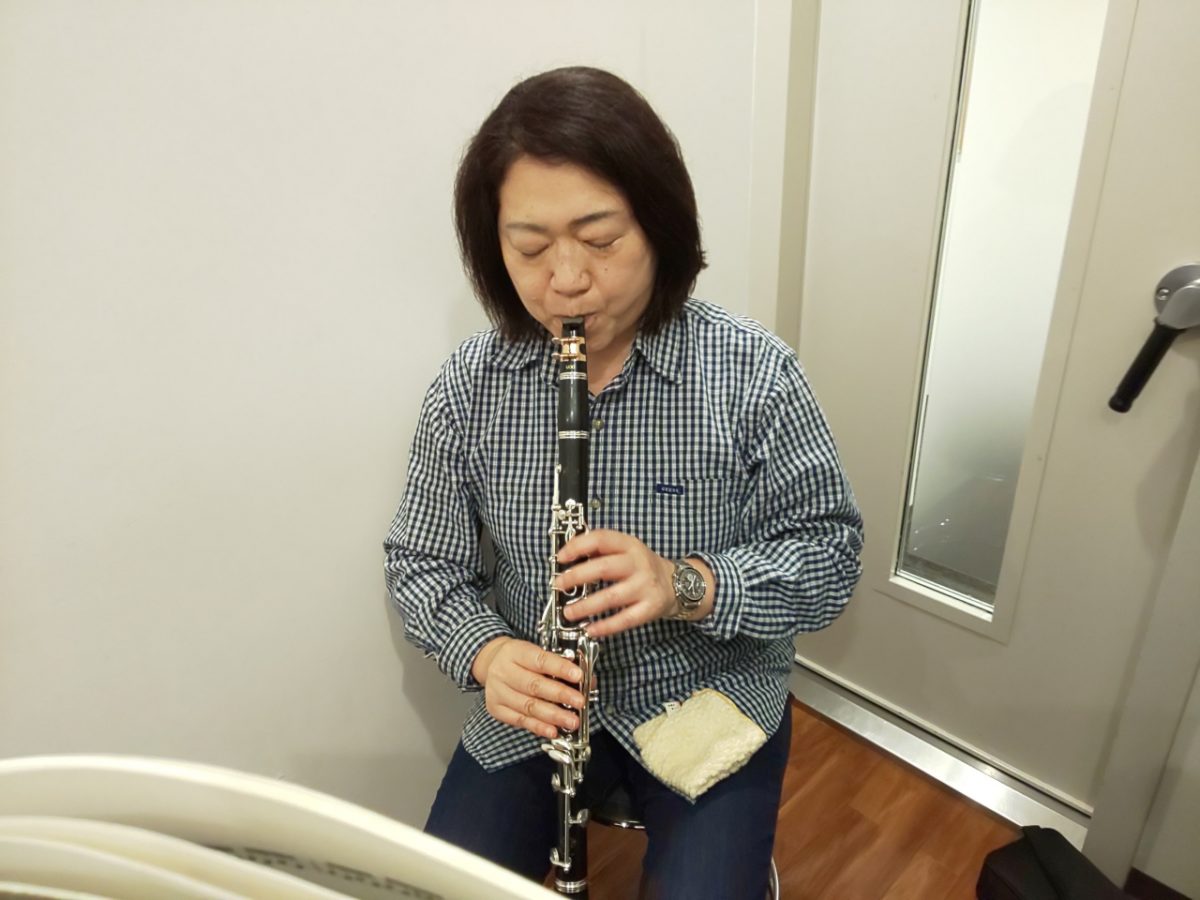 楽譜を見ながら座って演奏する生徒