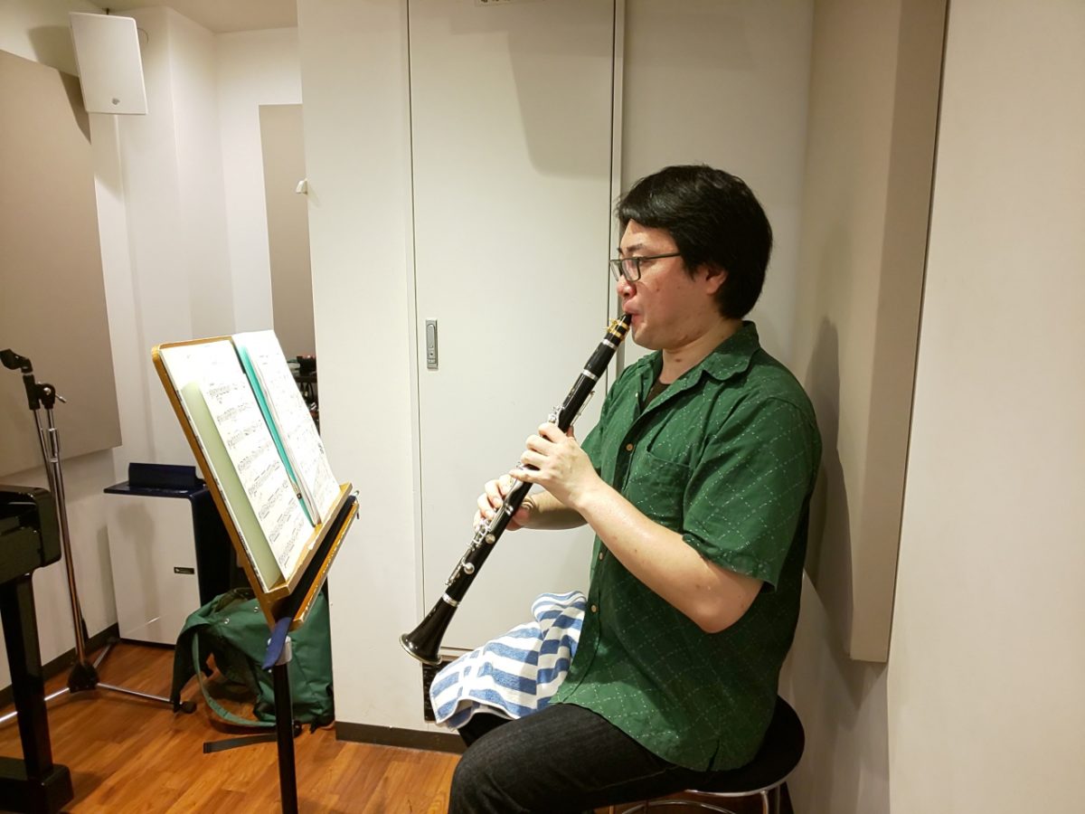 楽譜を見ながら座って演奏する生徒