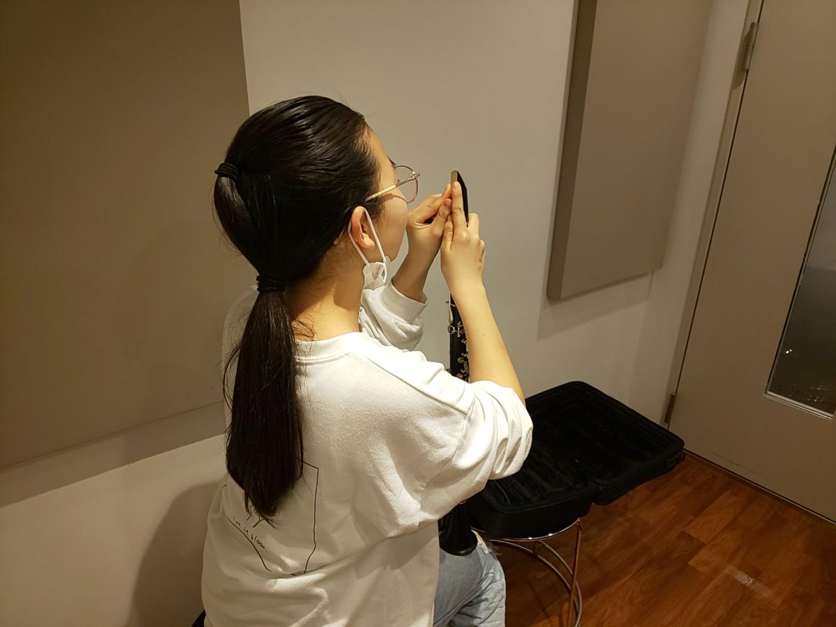 マウスピースにリードをセットする生徒