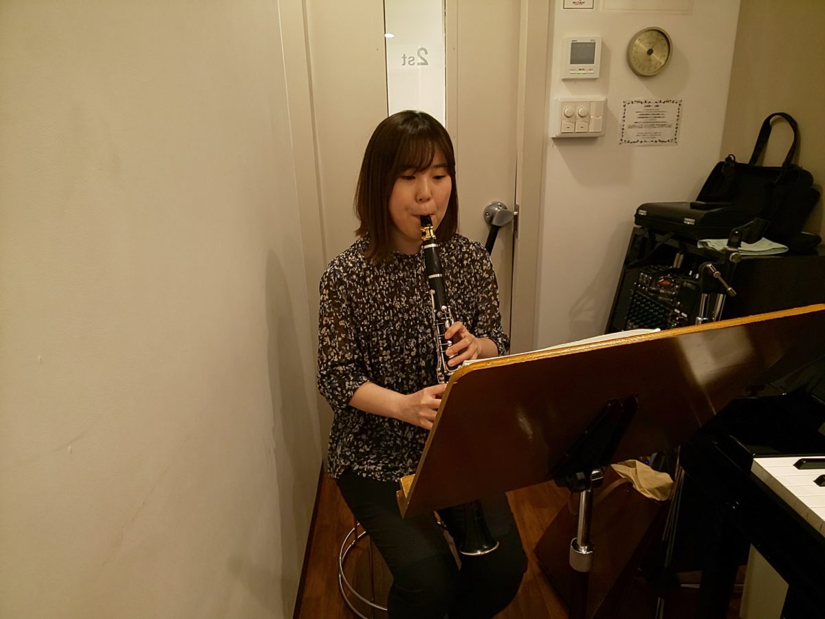 楽譜を見ながら座って演奏する生徒