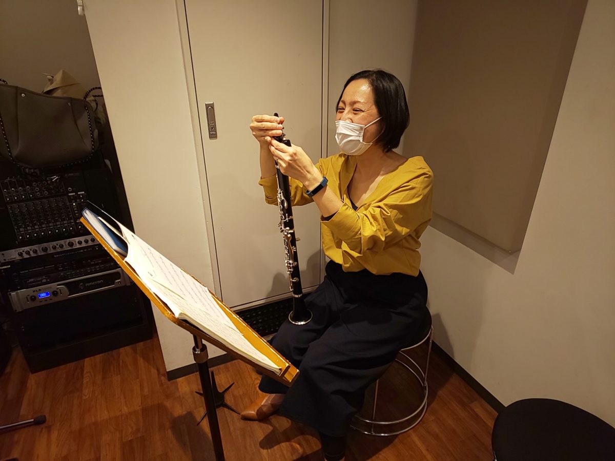 笑顔でマウスピースにリードをつける生徒