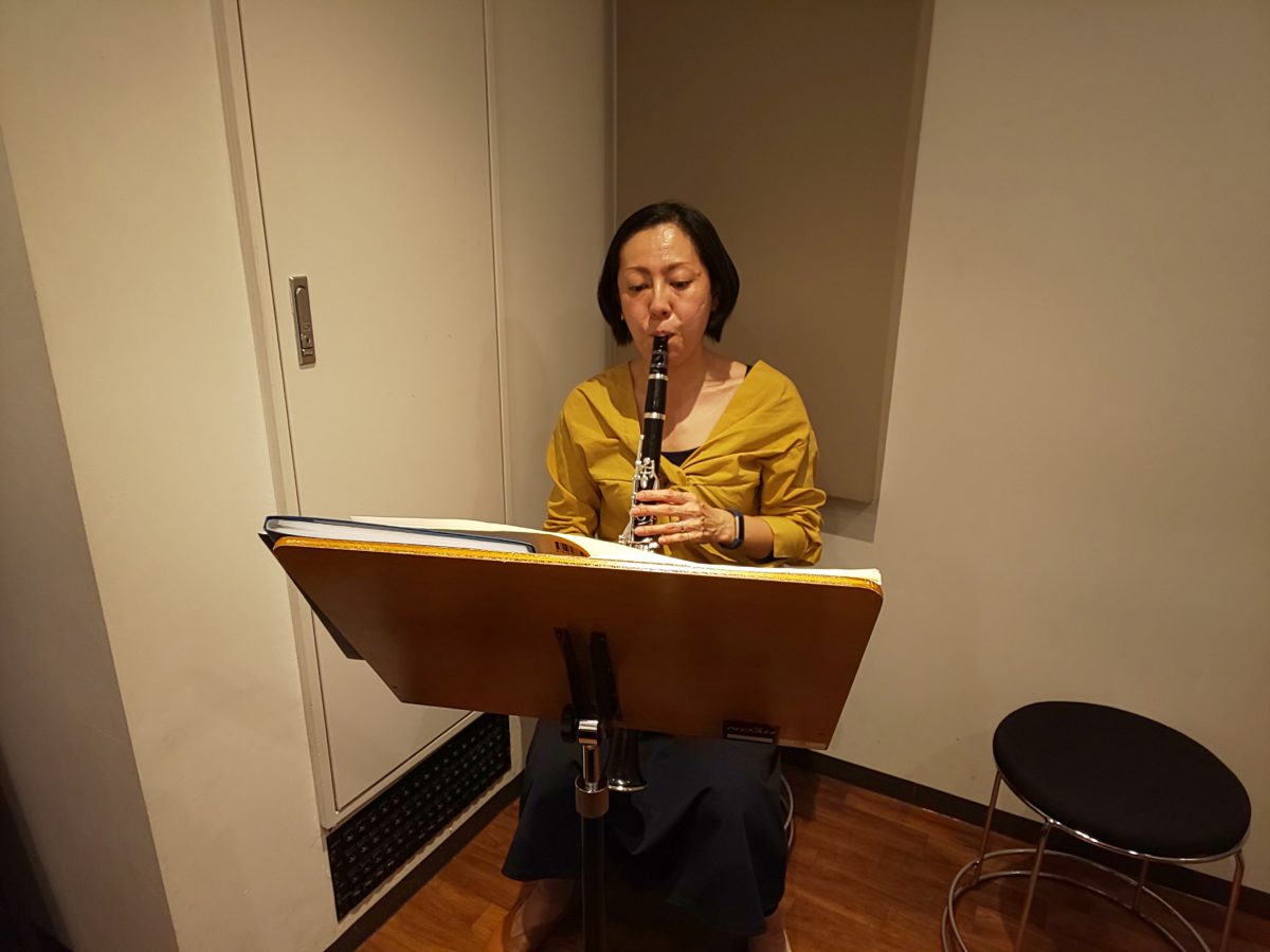 楽譜を見ながら座って演奏する生徒