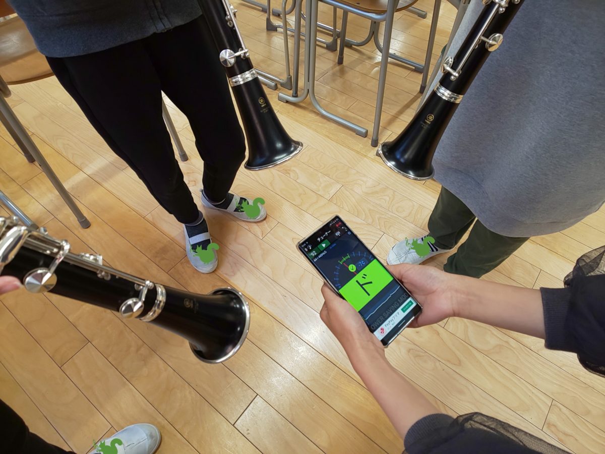 チューナーを使ってチューニングをする小学生