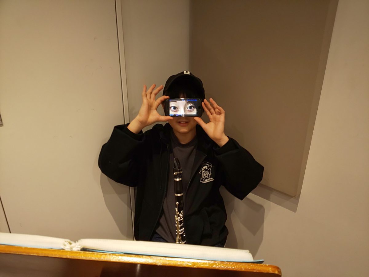 お母様の目が写ったスマートフォンで自分の目元を隠す生徒