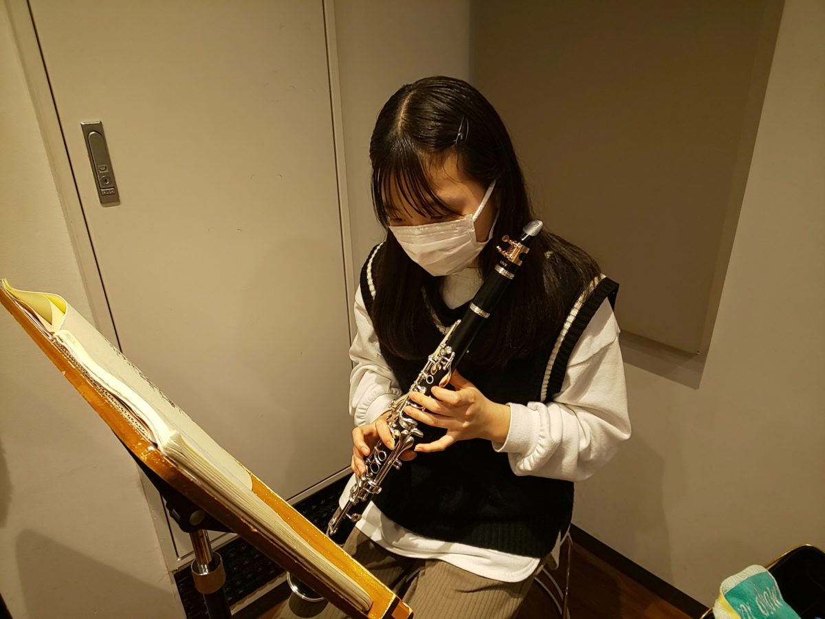 運指表を見ながら高音の指を確認する生徒