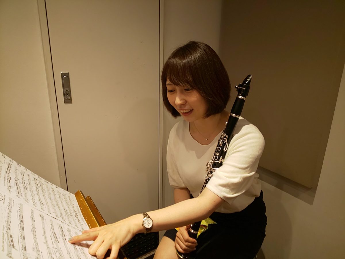笑顔で楽譜を指差しながら話をする生徒