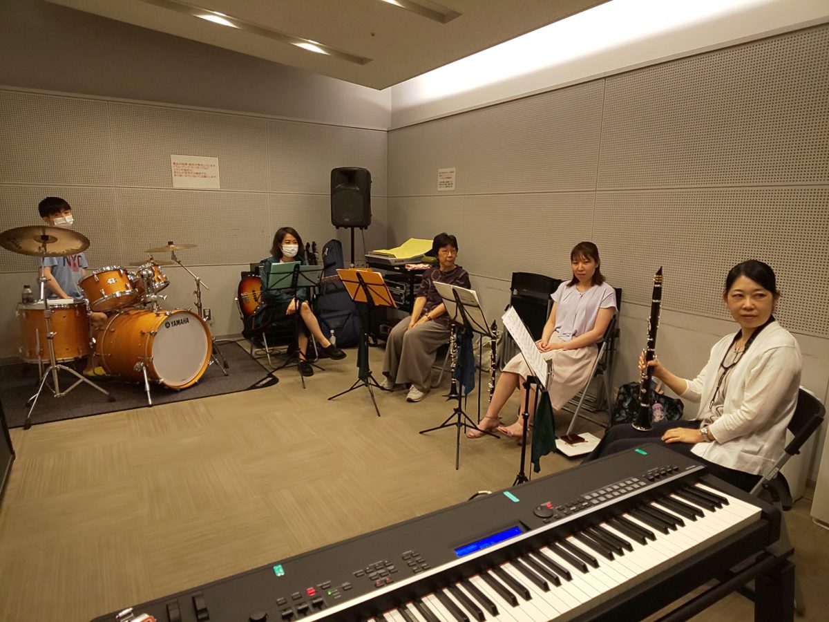 部屋の換気のために音を出すのを我慢するバンドアンサンブルメンバー