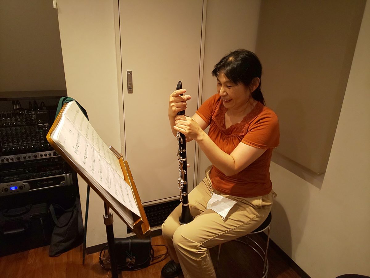 笑顔でクラリネットの掃除をする生徒