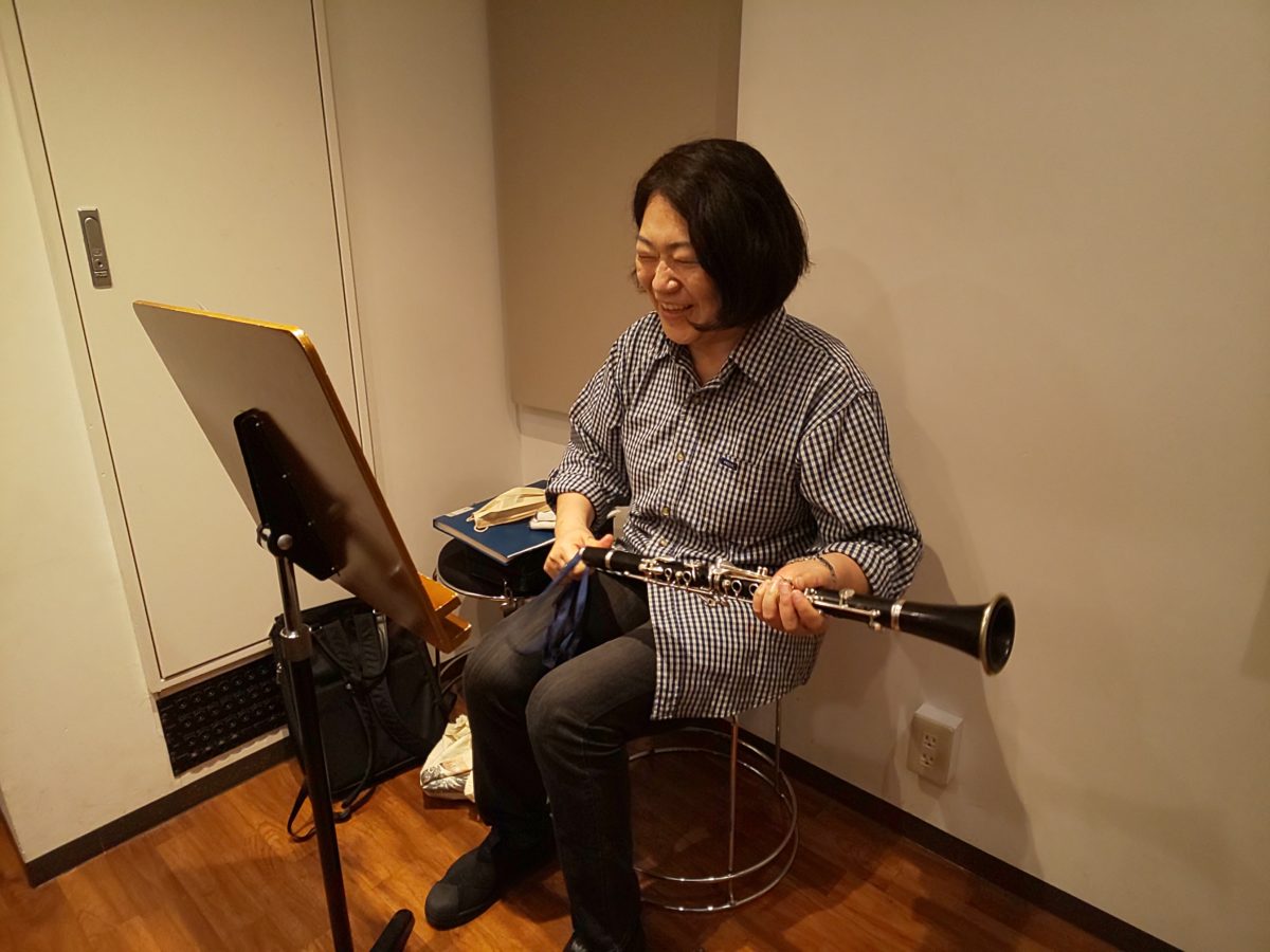 レッスン中にクラリネットを掃除しながら笑顔の生徒