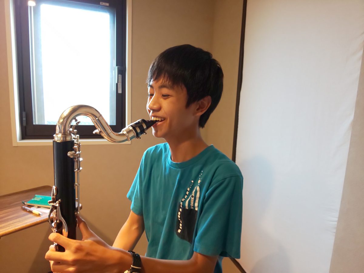 バスクラリネット演奏中に笑顔を見せる生徒