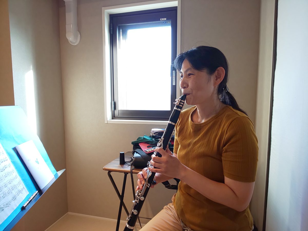 座ってクラリネットを吹く生徒